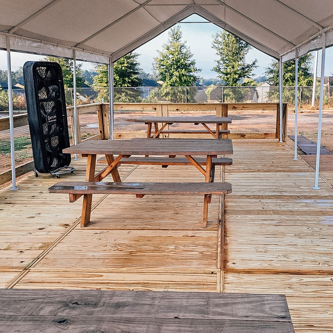 Covered event decking with picnic tables at Charlotte Regional Farmers Market, built by FlatSpot