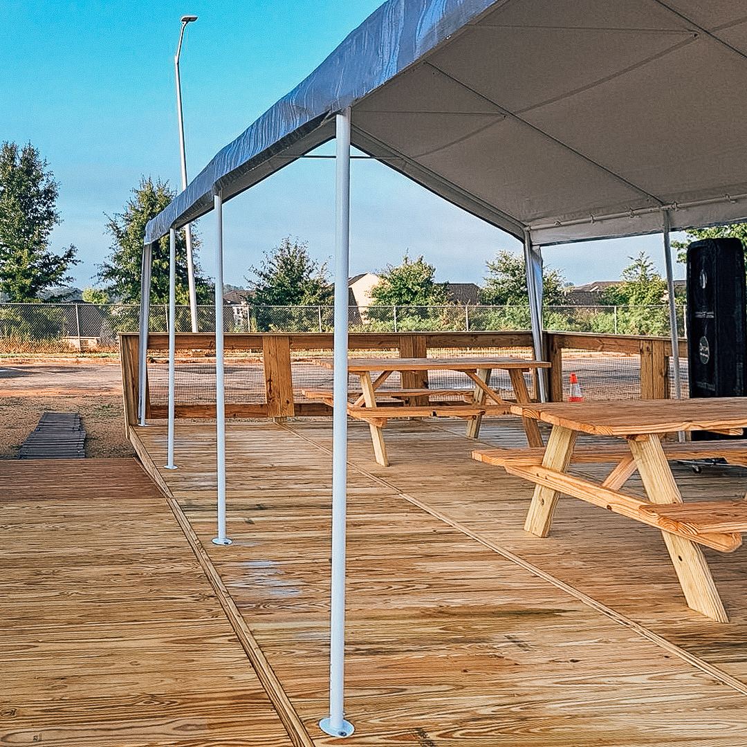 Covered commercial event deck with picnic tables at Charlotte Regional Farmers Market, built by FlatSpot